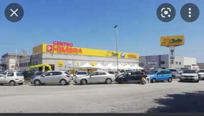a parking lot with cars parked in front of a store at Francesco&Maria in Villaggio Tedeschi