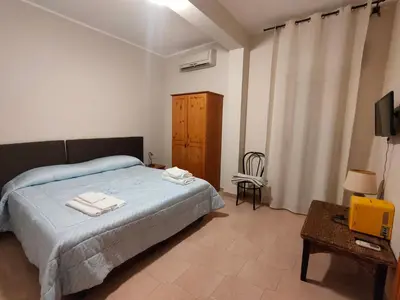 a bedroom with a bed and a television and a table at Hotel La Rocca in Roccapalumba