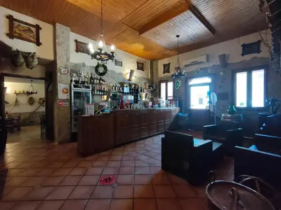 a bar in a restaurant with a counter and chairs at Hotel La Rocca in Roccapalumba