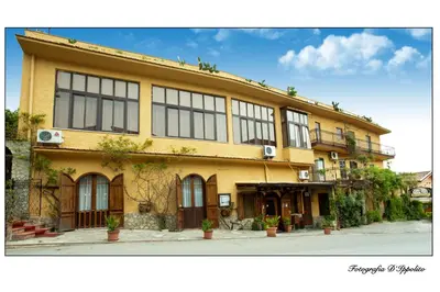 a large yellow building with windows on a street at Hotel La Rocca in Roccapalumba