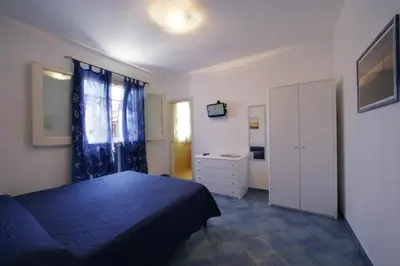 a bedroom with a blue bed and a dresser at Venere ed Enea - Appartamenti Vista Mare in San Vito lo Capo