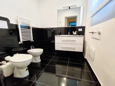 a black and white bathroom with a toilet and a sink at Cubacalatafimi Rooms in Palermo