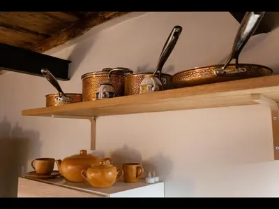 a shelf with copper pots and utensils on it at CityCenter Unique Apartment-Sleeps 2- Pet Friendly in Palermo