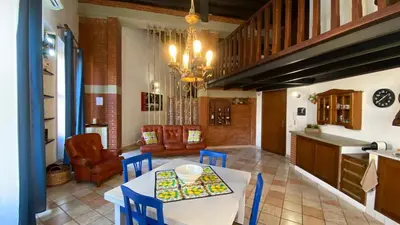 a kitchen and living room with a table and chairs at Casa Zagato Le Fuoriserie in Palermo