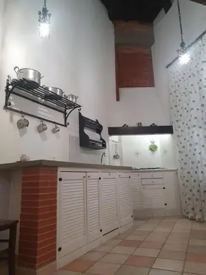 a kitchen with white cabinets and pots on the wall at Casa Monviso Le fuoriserie in Palermo