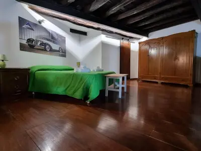 a bedroom with a green bed and a table at Casa Monviso Le fuoriserie in Palermo