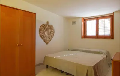 a bedroom with a bed and a wooden cabinet at Mansarda Belvedere in Alcamo Marina