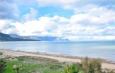 a view of a beach with mountains in the background at Mansarda Belvedere in Alcamo Marina