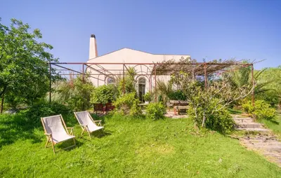two chairs sitting in the grass in front of a house at Cerasuola in Alia