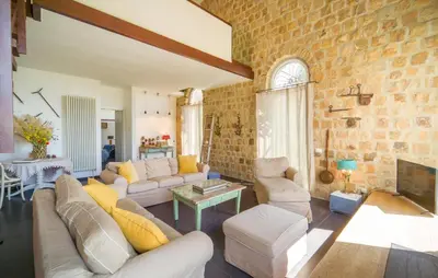 a living room with white furniture and a brick wall at Cerasuola in Alia