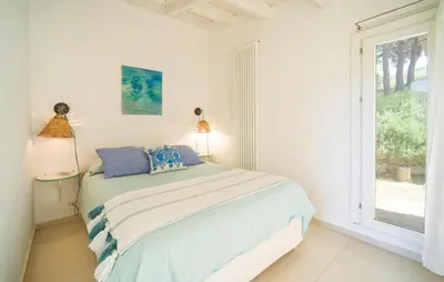 a white bedroom with a bed and a window at Nocellara in Alia