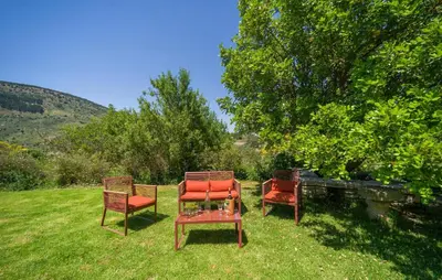 three chairs sitting in the grass in a yard at Biancolilla in Alia