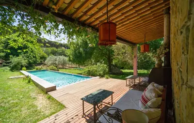 a wooden deck with a swimming pool in a yard at Biancolilla in Alia
