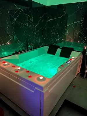 a jacuzzi tub in a room with a marble wall at Real suite spa in Palermo