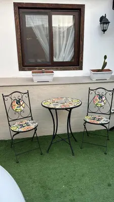 two chairs and a table in a room with a window at Real suite spa in Palermo