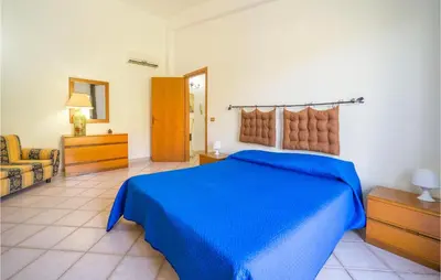 a bedroom with a blue bed and a chair at Villa Spera in Mandra Capreria