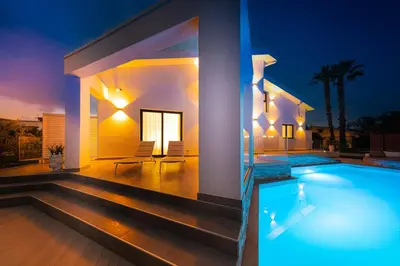 a villa with a swimming pool at night at Gelso Bianco Boutique Apartments in Campofelice di Roccella