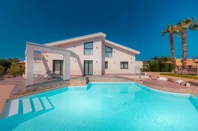 a large swimming pool in front of a house at Gelso Bianco Boutique Apartments in Campofelice di Roccella