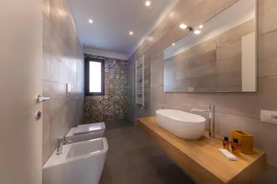 a bathroom with a sink and a tub and a toilet at Gelso Bianco Boutique Apartments in Campofelice di Roccella