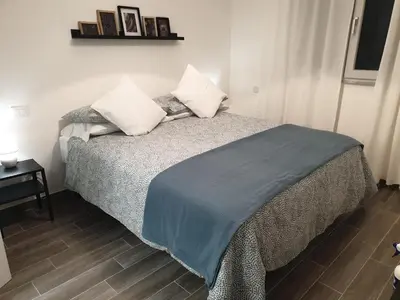 a bedroom with a bed with a blue blanket on it at Residenza Tarzanà in Palermo