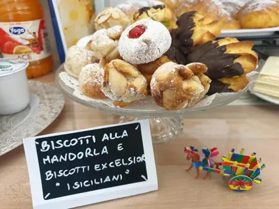 a plate of pastries on a table with a sign at Residenza Tarzanà in Palermo