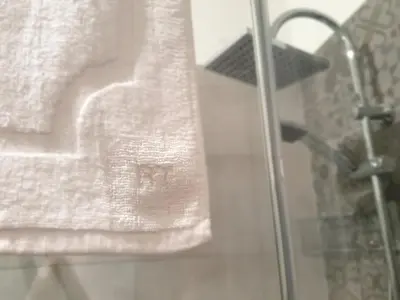 a white towel is hanging on a shower curtain at Residenza Tarzanà in Palermo