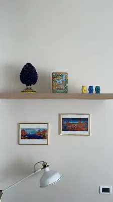 a shelf with three pictures and a vase on it at Arricría Room Suite in Palermo