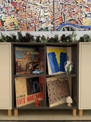 a book shelf with books and a map on the wall at Arricría Room Suite in Palermo