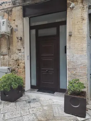 a brown door on a brick building with two plants at Bea Home in Palermo