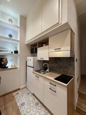 a kitchen with white cabinets and a refrigerator at Bea Home in Palermo