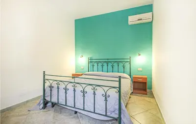 a bedroom with a bed and a green wall at Pietro 2 in San Vito lo Capo