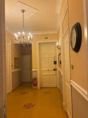 a hallway with a clock on the wall and a chandelier at A Casa di Anna - Apartment in Palermo
