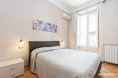 a white bedroom with a bed and a window at A Casa di Anna - Apartment in Palermo