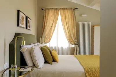 a bedroom with a bed with pillows and a window at Sui Tetti di Balarm Boutique Rooms in Palermo