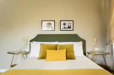 a bedroom with a large bed with two side tables at Sui Tetti di Balarm Boutique Rooms in Palermo