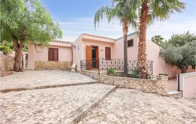 a house with palm trees in front of it at Pietro 3 in San Vito lo Capo