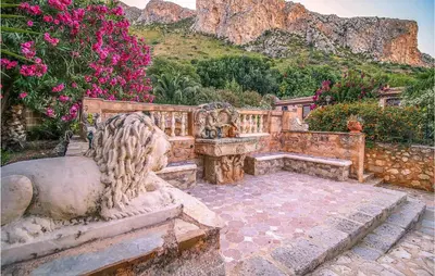 a stone bench in a garden with pink flowers at Pietro 3 in San Vito lo Capo