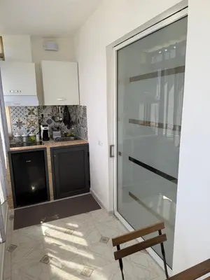 a kitchen with a sliding glass door and a bench at Oreto Apartment in Palermo