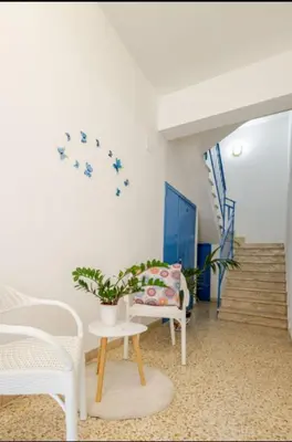 a living room with a chair and a table at Perla Home Speciale Vacanze 2026, Casa perfetta per gruppi coppie e famiglie vivi la Sicilia a modo tuo in Alcamo