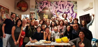 a group of people posing for a picture at a table at A Casa di Amici in Palermo