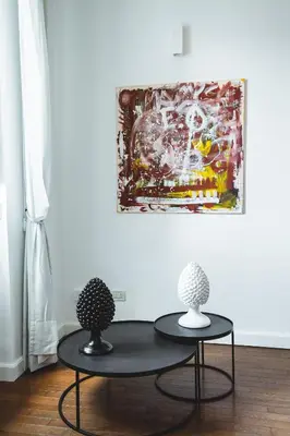 two black tables in a room with a painting on the wall at ChiChi Home in Palermo