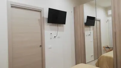 a bedroom with a tv on the wall and a mirror at Le Due Pigne - Palermo in Palermo