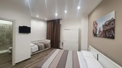 a bedroom with a bed and a tv on a wall at Garibaldi Rooms 29 - Piazza Marina a Palermo - In pieno Centro. in Palermo