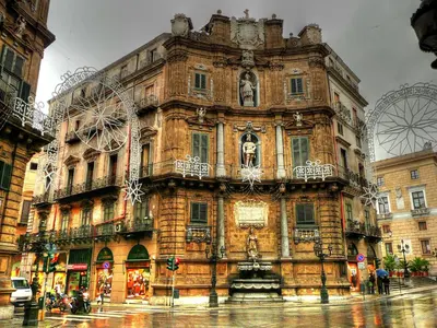 a large building in a city with a ferris wheel at Garibaldi Rooms 29 - Piazza Marina a Palermo - In pieno Centro. in Palermo