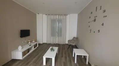 a living room with two white tables and a television at Garibaldi Rooms 29 - Piazza Marina a Palermo - In pieno Centro. in Palermo