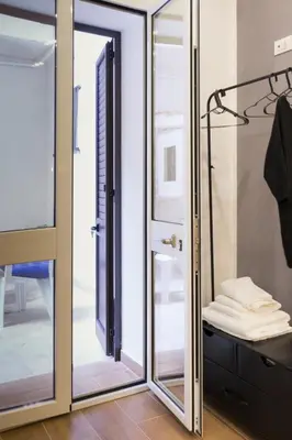 a glass shower door in a room with a closet at Casa Villafilippina in Palermo