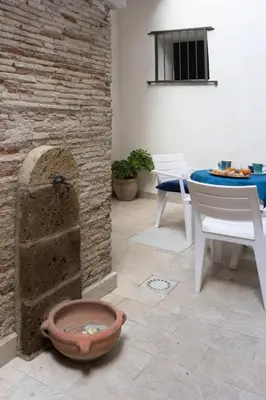 a patio with a stone fireplace and a table and chairs at Casa Villafilippina in Palermo