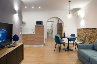 a living room with a couch and a table and chairs at Casa Villafilippina in Palermo