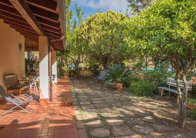 a patio with chairs and tables and trees at Villa Flora in Castellammare del Golfo