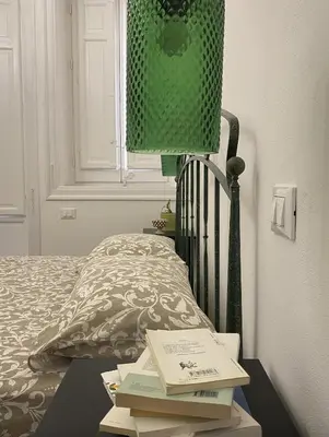 a bed with a table with books on it at Il gallo di Eracle - Charming suites & rooms in Termini Imerese